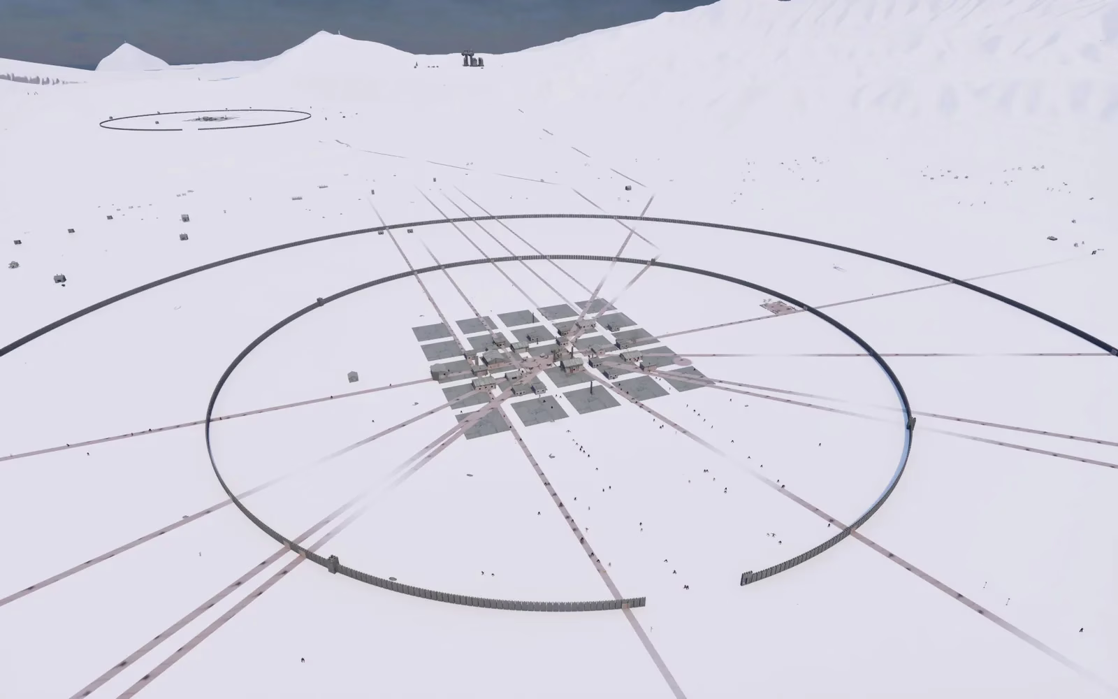 Two dark wall rings around a small grid of lots and buildings, with roads running out across a wide white plain toward snowy hills and dark water.