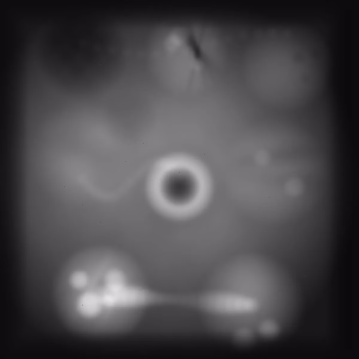 A blurry grey heightmap, lighter where the land is higher, with a dark ring-shaped crater in the middle and bright patches along the bottom.