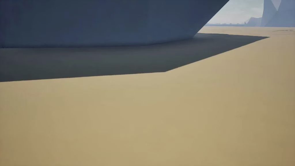 A big grey-blue faceted slab of stone looming at the top left over flat yellow sand, with pale mountains far off to the right.