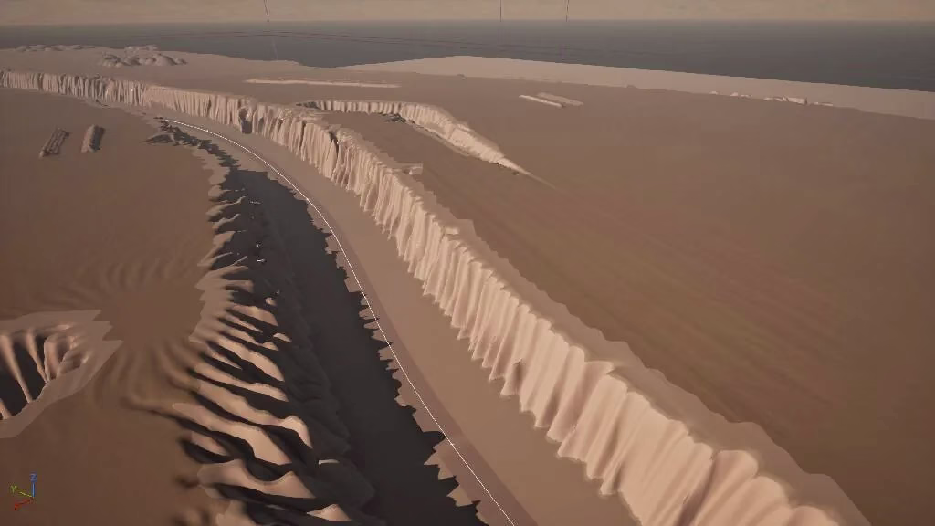 A tan landscape with a deep river channel cut between tall pale ribbed cliffs, running toward a dark sea under a hazy sky.