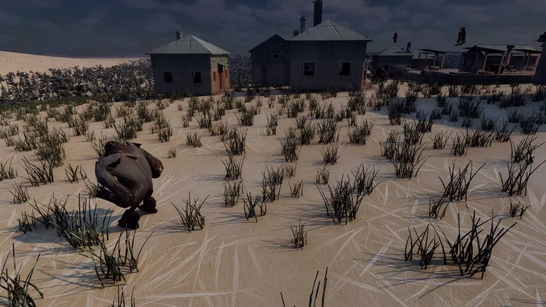 A hunched dark figure seen from behind, standing in tufts of grass on pale sand with grey houses behind it.