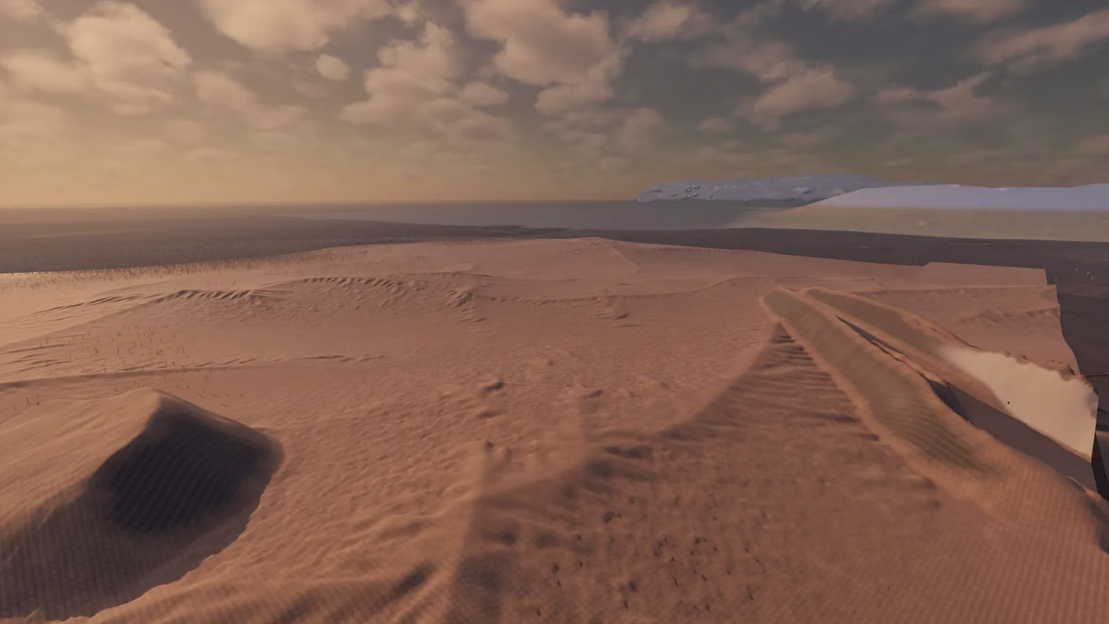 Rippled orange sand dunes under heavy clouds, a shadowed hollow at the lower left, a long gully cutting down the right side to a sheer pale edge, and a white plateau beside a dark sea on the horizon.