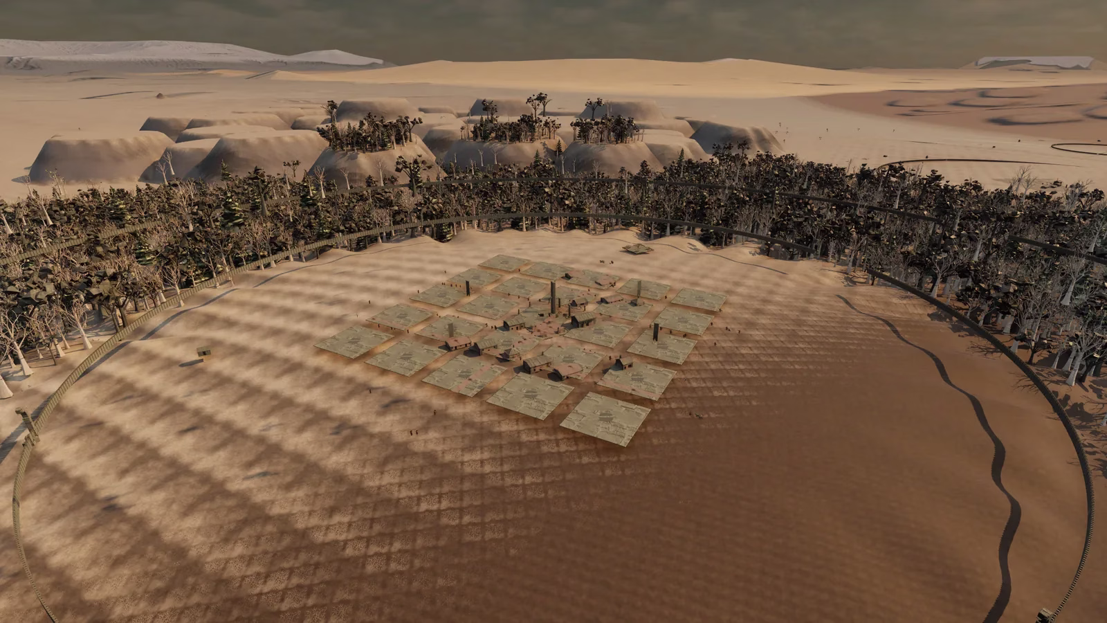 An aerial view of a marsh town: a grid of flat green slabs with a few small huts in the middle, a ring of wall around it, trees behind, and pale mesas and dunes on the horizon.
