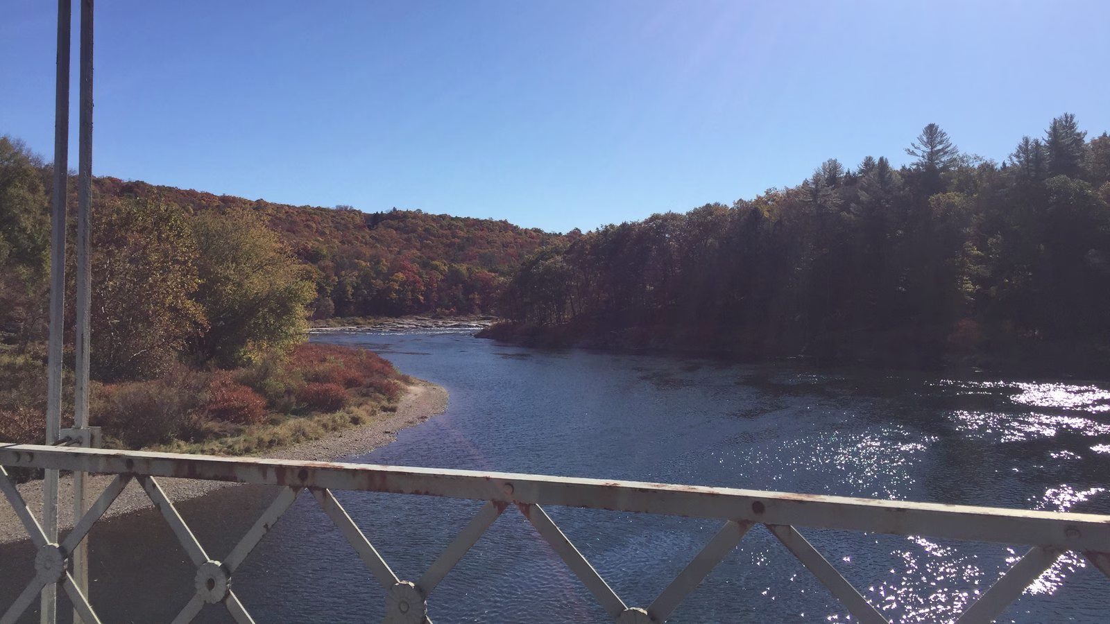 Blue riffled water between hills in fall color.